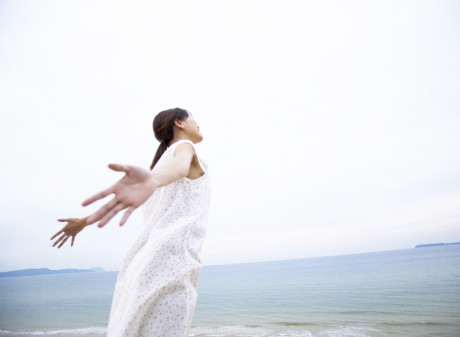 Woman by Ocean with Arms Outstretched