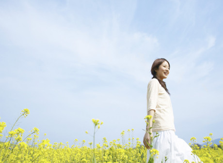 Young Woman Walking Through Yellow Wildflowers